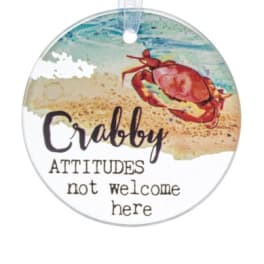 Round beach-themed hanging ornament with a red crab and playful text.