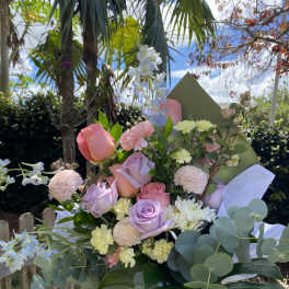Pastel bouquet of roses, orchids, and mums with eucalyptus