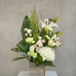 White lilies and pale roses in a wooden box arrangement