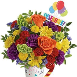 Colorful bouquet in a decorated vase with balloons and a celebration sign