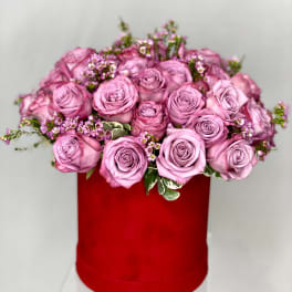 Pink roses arranged in a red hat box