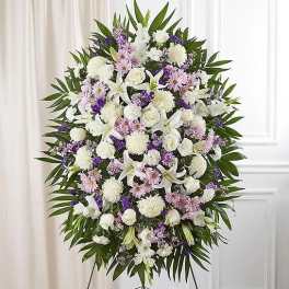 Large white and lavender funeral spray on an easel