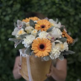 Bouquet of orange gerbera daisies and white roses in a tan box