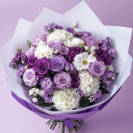 Bouquet of purple and white roses with daisies wrapped in white and purple paper