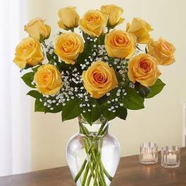 Yellow roses arranged in a clear glass vase with baby's breath