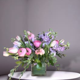 Pink and lavender bouquet in a square glass vase