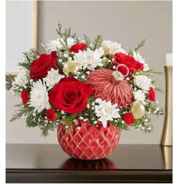 Red roses and white daisies in a red patterned vase with gold ornaments