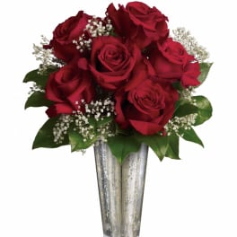 Tall silver vase of red roses with white filler flowers
