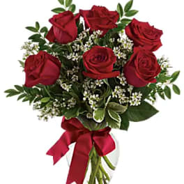 Bouquet of red roses with white filler flowers in a glass vase