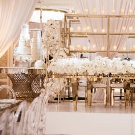 White floral wedding reception setup with gold frames and candles