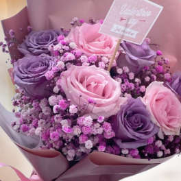 Pink and purple rose bouquet with baby's breath and a Valentine's Day card