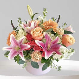 Pink lilies and peach roses in a round vase