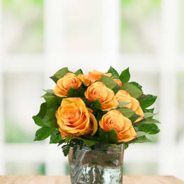 Orange roses arranged in a clear glass vase