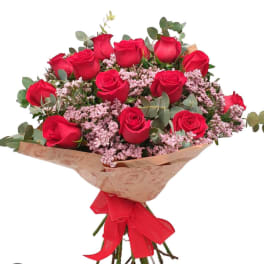 Bouquet of red roses with pink filler flowers and a red ribbon