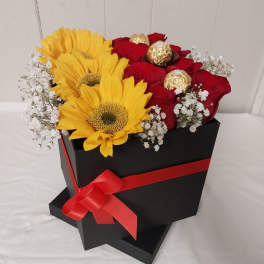 Red roses and yellow sunflowers in a black gift box with a red ribbon