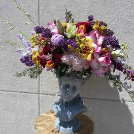 Colorful mixed bouquet arranged in a blue bust vase