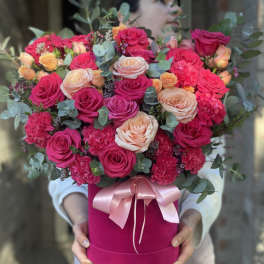 Bouquet of pink and peach roses in a magenta hat box with a pink ribbon