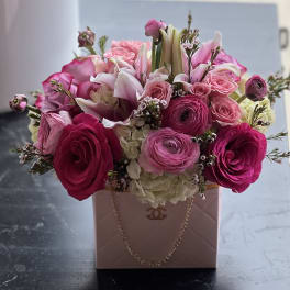 Pink and white flower arrangement in a blush handbag-style box