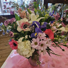 Mixed bouquet with pink, purple, white, and blue flowers in a vase