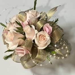 Small bouquet of pale pink roses with gold ribbon and pearl accents