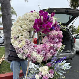 Large floral wreath with pink, purple, and white roses on an easel