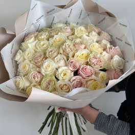 Large bouquet of pale pink and cream roses wrapped in white paper