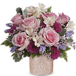 Pink roses and purple flowers arranged in a glittery vase