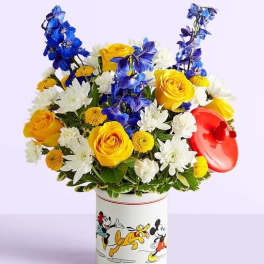 Bouquet of yellow, white, and blue flowers in a Mickey Mouse tin