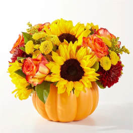 Sunflowers and roses arranged in a pumpkin-shaped container