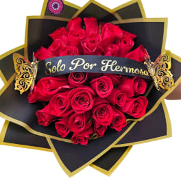 Bouquet of red roses wrapped in black and gold paper with a ribbon