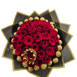 Round bouquet of red roses encircled by gold-wrapped chocolates in black and gold paper with a gold bracelet accent