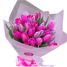 Bouquet of pink and lavender tulips wrapped in pale paper