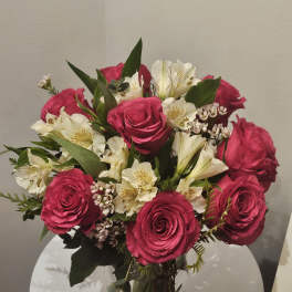 Pink roses and white lilies arranged in a clear glass vase