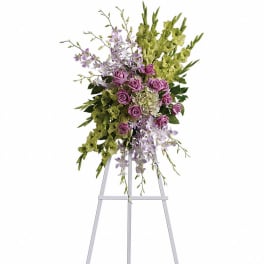 Tall floral spray with purple roses and green blooms on a stand