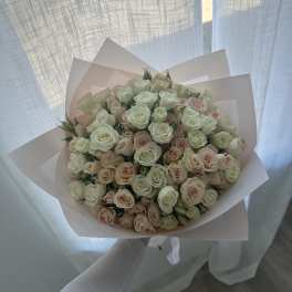 Bouquet of pale pink and white roses wrapped in blush paper