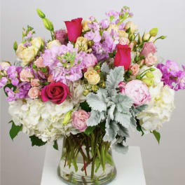 Mixed pink and white flowers arranged in a clear glass vase