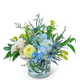 Blue and white flowers arranged in a clear glass vase