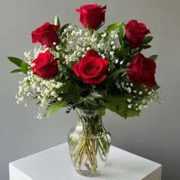 Bouquet of red roses and baby's breath in a clear glass vase