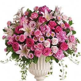 Pink and white floral arrangement in a white urn vase