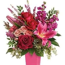 Pink and red floral arrangement in a tall pink vase