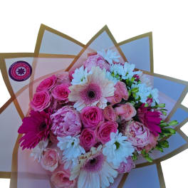 Pink and white mixed bouquet with roses and daisies wrapped in translucent paper