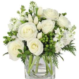 White roses and tulips in a clear glass vase