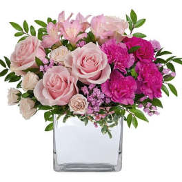 Pink roses and carnations in a clear square vase