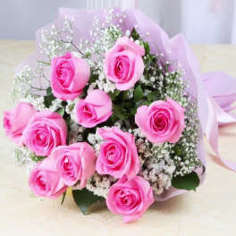 Bouquet of pink roses with white baby's breath wrapped in pale pink paper