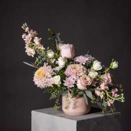 Pink and white floral arrangement in a blush vase