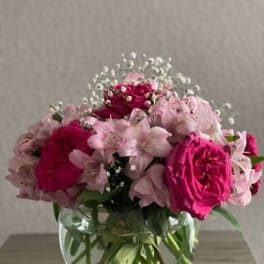 Pink roses and pale pink flowers in a clear glass vase