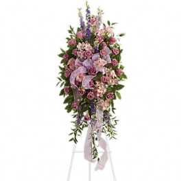 Tall standing floral spray with pink and purple flowers on a white easel