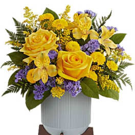 Yellow roses and purple flowers in a white vase on a stand