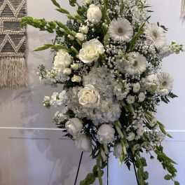 White floral standing spray with roses, gerbera daisies, and greenery