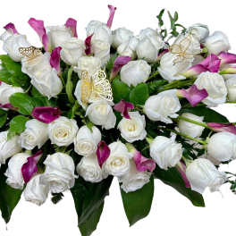 White roses and magenta calla lilies in a low arrangement